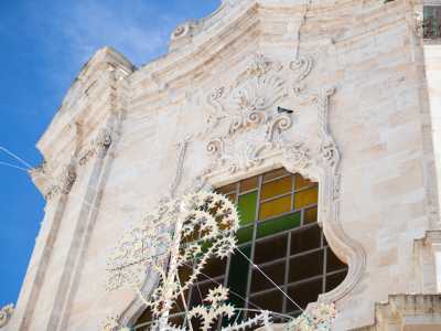 Il prospetto, diviso orizzontalmente da un cornicione, si apre nel secondo ordine con un finestrone a vetri colorati...